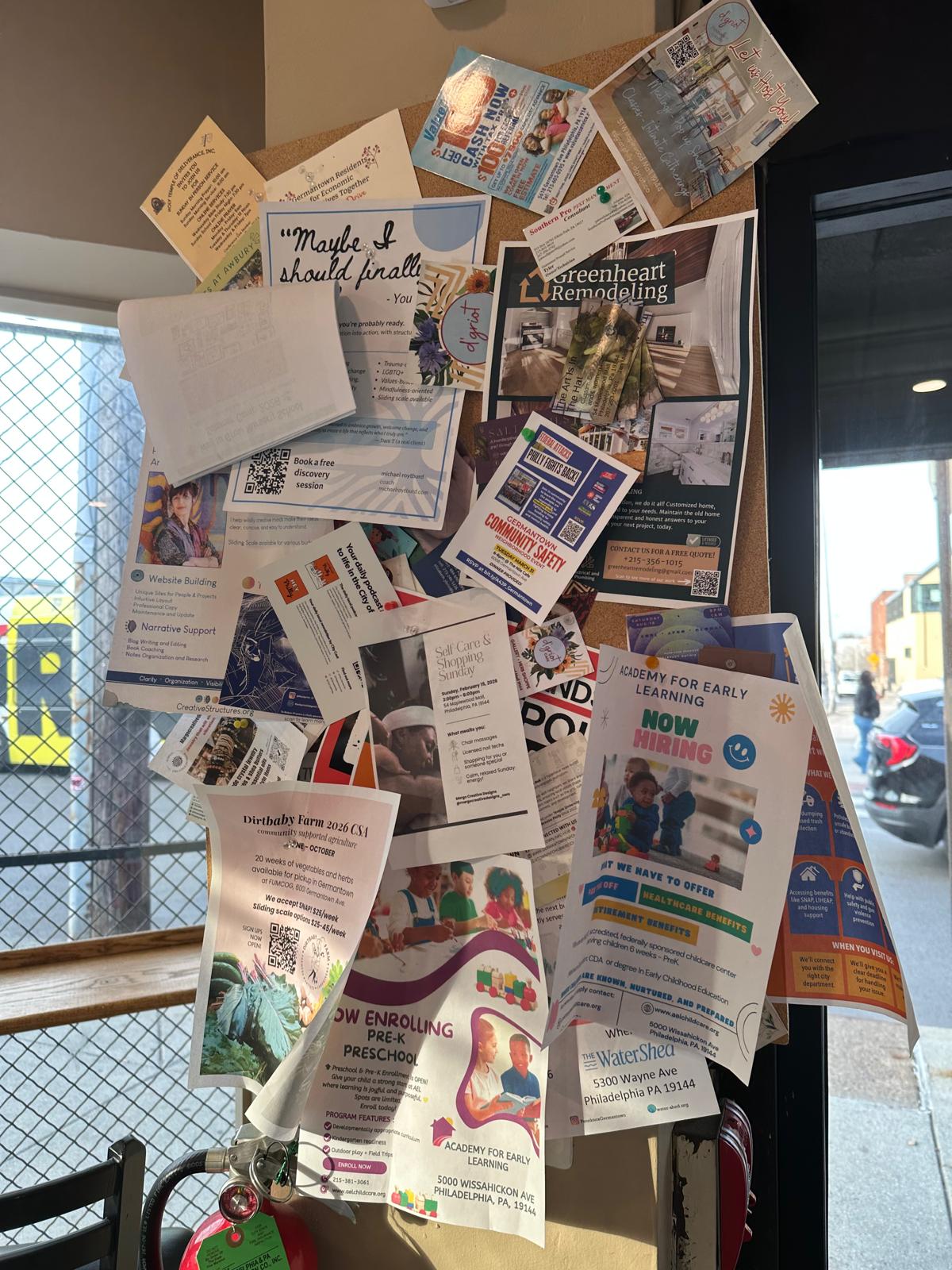 A cluttered traditional paper notice board in a local business